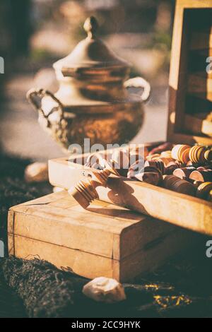 Stillleben mit Teekessel und Schachfiguren in Holzkiste, nachbearbeitet, um einen Vintage-Look zu haben Stockfoto