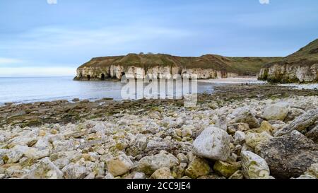 Malerische Bucht, felsiger Strand, hohe zerklüftete Kreidefelsen, ruhiges Meer, blauer Sommernachthimmel - Thornwick Bay, Flamborough, East Yorkshire Coast, England, Großbritannien. Stockfoto