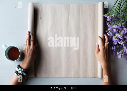 Eine Dame öffnet ein großes Papier, um etwas zu zeichnen Ihre Hände