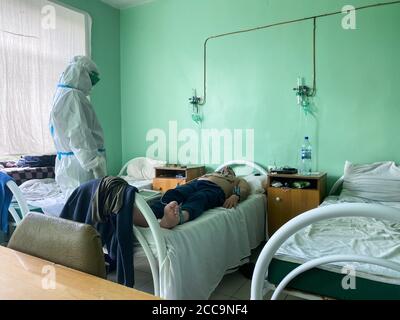 Oryol, Russland - August , 2020. Arzt mit Elektrokardiogramm Ausrüstung, die Kardiogramm-Test zu männlichen Patienten im Krankenhaus Stockfoto