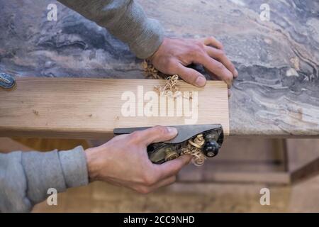 Der Zimmermann verwendet einen Jointer. Draufsicht. Stockfoto