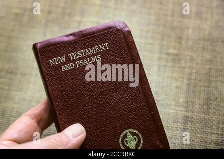 Eine rote Gideon's Bibel auf einem neutralen Hintergrund. Das Buch enthält das Neue Testament und die Psalmen plus die Gebote. Stockfoto