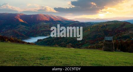 Nebliger Morgen im Herbst Berge. Landschaft Landschaft in Herbstfarben. Bunte Bäume auf dem Hügel. Landschaft unter einem Himmel mit Wolken bei Sonnenaufgang Stockfoto