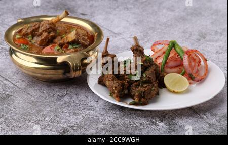 Bhuna Gosht Mutton Masala ODER Indian Lamb Masala und Hammelcurry serviert mit Zwiebeln auf launischem Hintergrund. Stockfoto