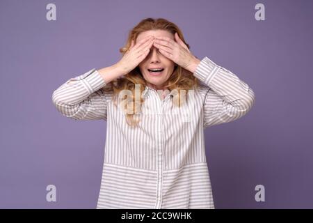 Kaukasische reife Frau Abdeckung Augen warten auf Überraschung. Stockfoto