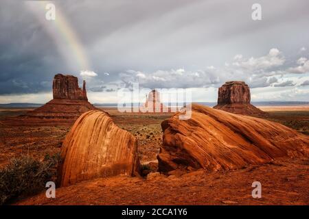Dunkle Wolken und ein Regenbogen über dem Monument Valley, Arizona Stockfoto