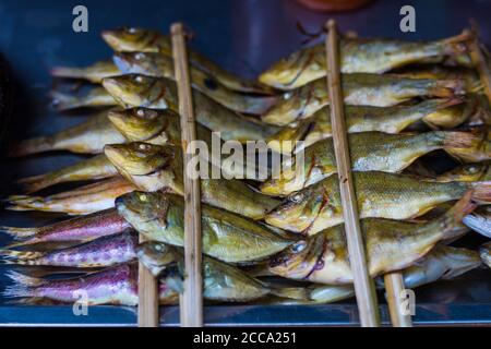 Gegrillte Sardinen auf einem asiatischen Markt. Hier ist der Fischmarkt sehr beliebt und das Essen ist immer frisch und lecker Stockfoto