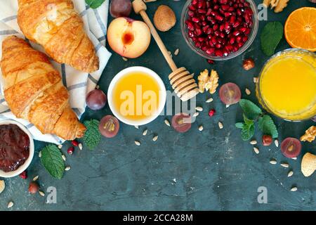 Gesundes Frühstückskonzept: Croissant, frisches Obst und Saft. Draufsicht mit Kopierbereich. Stockfoto