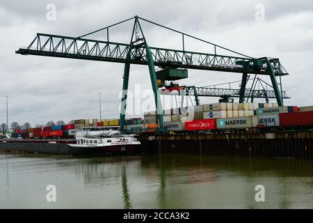 KÖLN, 21. Feb 2020: Im Niehler Hafen in Köln wird ein Containerschiff von einem Kran mit Containern beladen Stockfoto