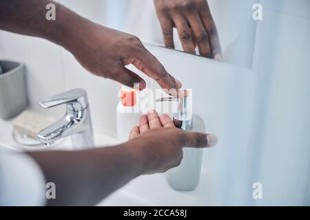 Fokussiertes Foto auf dunkelhäutigen Mann, der im Badezimmer ist Stockfoto