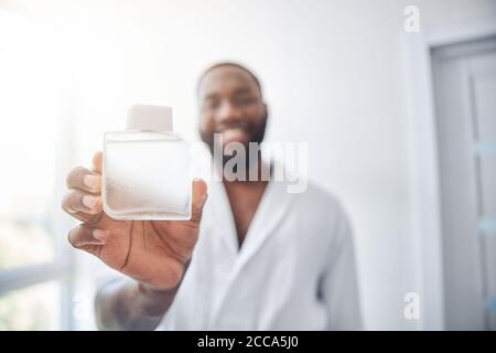 Nahaufnahme von glücklichen Mann, der seine Lieblings-Parfüm demonstriert Stockfoto