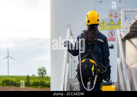 Asiatische Frau Inspektionsingenieur Vorbereitung und Fortschrittskontrolle einer Windenergieanlage mit Sicherheit im Windpark in Thailand. Stockfoto