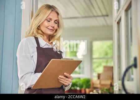 Frau in einer Schürze, die in der Tür steht Stockfoto