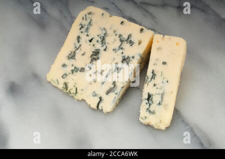 Studioaufnahme einer Scheibe Blauschimmelkäse, auf dem sich die Kamera aufraht Eine Marmorplatte - John Gollop Stockfoto