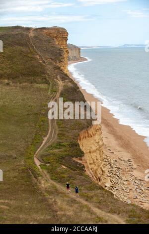 Zwei Läufer in der Nähe der Burton Freshwater Bay entlang des South West Coast Path an der Jurassic Coast, Dorset, England, Großbritannien Stockfoto