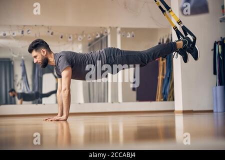 Fokussierter männlicher Athlet, der eine Plank-Übung macht Stockfoto