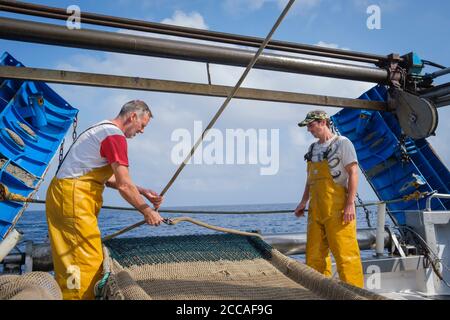 Fischer, die an einem Trawler arbeiten. Palamós. Costa Brava. Katalonien. Spanien. Stockfoto