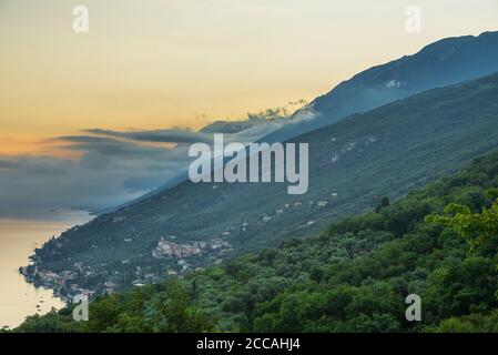 Bunt zerlumpte Wolken über dem Monte Baldo und dem nördlichen Ende und Ostufer des Gardasees bei Sonnenaufgang, Venetien, Trentino, Italien Stockfoto