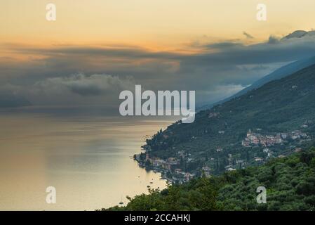 Bunt zerlumpte Wolken über dem Monte Baldo und dem nördlichen Ende und Ostufer des Gardasees bei Sonnenaufgang, Venetien, Trentino, Italien Stockfoto