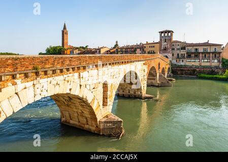 Die römische Ponte Pietra Steinbogenbrücke über die Etsch in der Altstadt von Verona ist in der Abendsonne, Venetien, Italien beleuchtet Stockfoto