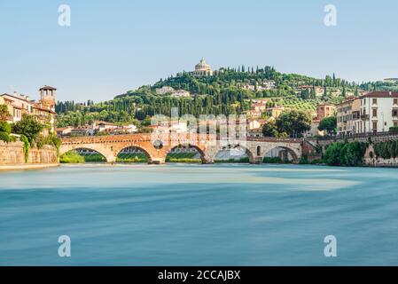 Die römische Ponte Pietra Steinbogenbrücke über die Etsch in der Altstadt von Verona vor der mediterranen Landschaft in der Morgensonne, Italien Stockfoto