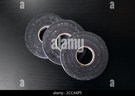 Drei Rollen doppelseitiges Klebeband auf Holztisch Stockfoto