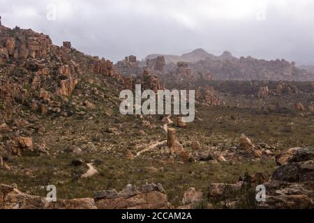 Ein Wanderweg schlängelt sich durch die verwitterten Sandsteinsäulen der nördlichen Cederberg Mountains, Westkap Südafrika, an einem kalten bewölkten Nachhall Stockfoto