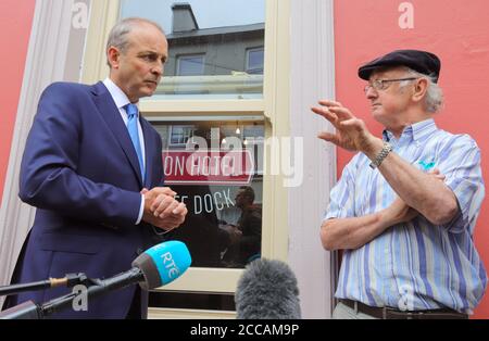 Ein Taoiseach Micheal Martin plaudert mit Einheimischen auf der Bridge Street, als er die überschwemmten Häuser und Geschäfte von Skibbereen am Morgen besucht, nachdem eine Flut umfangreiche Schäden an einer Reihe von Gebäuden in der beliebten irischen Touristenstadt verursacht hatte. Stockfoto