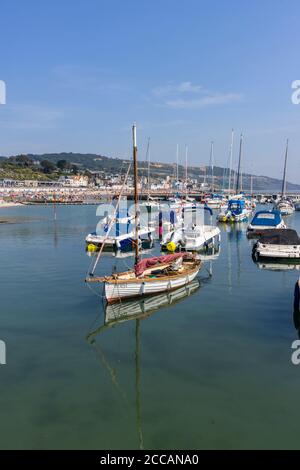 Segel- und Motorboote liegen im Cobb in Lyme Regis, einem beliebten Badeort an der Jurassic Coast in Dorset, Südwestengland Stockfoto