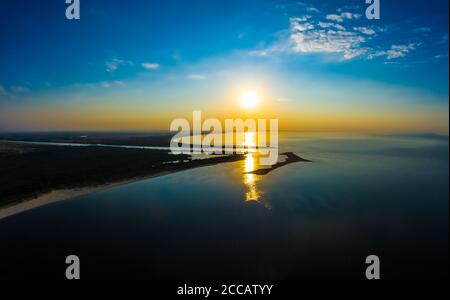 Minimalistische Luftlandschaft - Sonnenuntergang über ruhigem Wasser. Ostsee. Stockfoto