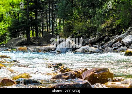 Kasol Manali - der glühende Parvati-Fluss in den Schneebirgen von Himachal Pradesh, Indien. Flusswasser rauscht im Tal der Götter. Himachal Pradesh. Stockfoto