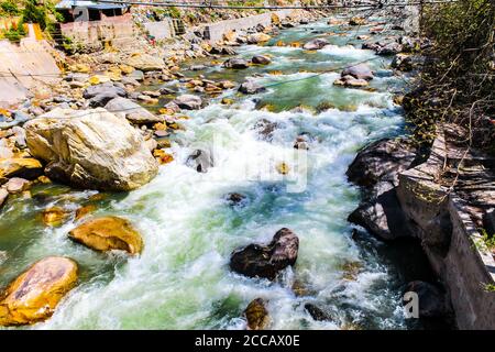 Kasol Manali - der glühende Parvati-Fluss in den Schneebirgen von Himachal Pradesh, Indien. Flusswasser rauscht im Tal der Götter. Himachal Pradesh. Stockfoto