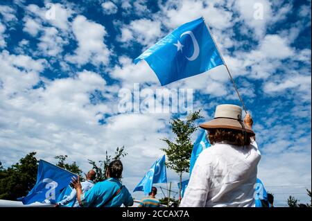 Während der Demonstration winken Demonstranten Uiguren-Fahnen.Extinction Rebellion Fashion Action NL (XRFA) hat sich mit der Ostturkestan Organization Alliance zusammengetan, um die öffentliche Aufmerksamkeit auf die Diskriminierung der Uiguren in China zu lenken. Demonstranten begannen am Koekamp, zur chinesischen Botschaft zu gehen, um eine offizielle Erklärung abzugeben, und Druck auf die niederländische Regierung und die chinesische Botschaft auszuüben, jetzt zu handeln und diese ethnische Säuberung zu stoppen. Stockfoto