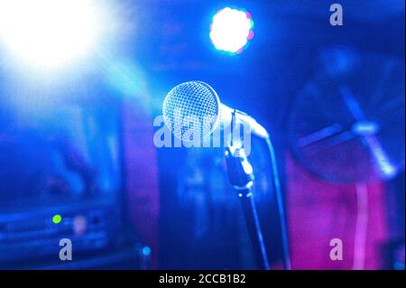 vokalmikrofon in einer Reihe von Scheinwerfern auf einem Konzert Bühne in einem Club Stockfoto