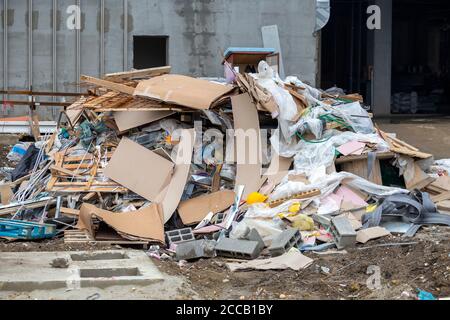 Haufen Bauabfälle vor einem unfertigen Gebäude. Stockfoto