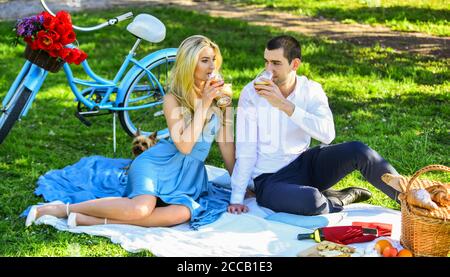 Express Positivität. Genießen Sie die Natur zusammen. Mit Picknick im Stadtpark. Mann und Frau entspannen mit Esskorb. Romantische Reisende Paar beobachten schöne Landschaft. Paar in der Liebe auf grünem Gras. Stockfoto