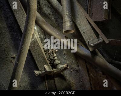 Haufen staubiger, schmutziger rostiger Rohre auf dem Boden einer verlassenen Fabrik, Conshohocken, Pennsylvania, USA Stockfoto