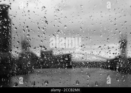 Regen auf dem feuchten Glas der Media City Fußgängerbrücke über den Manchester Ship Canal, Salford Quays, Manchester, England, UK: Schwarz-weiß Version Stockfoto