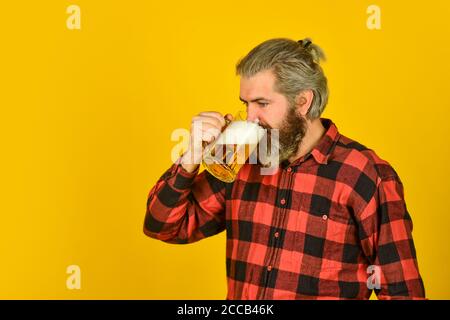 Weizenbier. Trinken Sie Bier vom Fass an der Theke in der Kneipe. Entspannter schöner Mann schlürft leckeres Bier. Genießen Sie Glas in der Kneipe. Erwarten Sie frisches kaltes Lagerbier. Nach einem harten Arbeitstag. Stockfoto