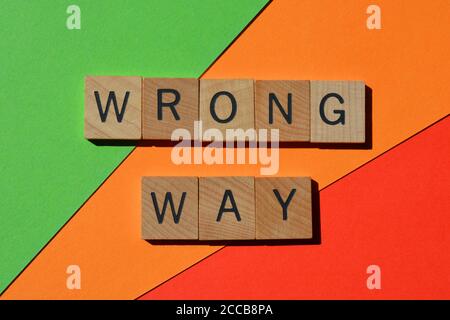 Falsch, Wort in hölzernen Buchstaben isoliert auf rotem, orangefarbenem und grünem Hintergrund Stockfoto
