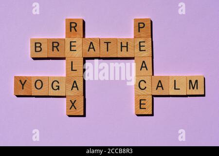 Yoga, Atmen, Entspannen, Frieden, Ruhe, Kreuzworträtsel in Holzbuchstaben in Kreuzworträtsel-Form isoliert auf violettem Hintergrund Stockfoto