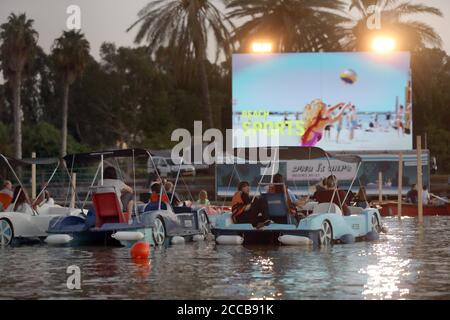 Tel Aviv, Israel. August 2020. Am 20. August 2020 sitzen Menschen in Booten, wie sie in einem schwimmenden Kino in Tel Aviv, Israel, sitzen. Das schwimmende Segelkino ist eine Initiative der Stadtverwaltung von Tel Aviv, um Menschen während der Beschränkungen der COVID-19-Pandemie kulturelle Veranstaltungen zu bieten. (Gideon Markowicz/JINI via Xinhua) Quelle: Xinhua/Alamy Live News Stockfoto