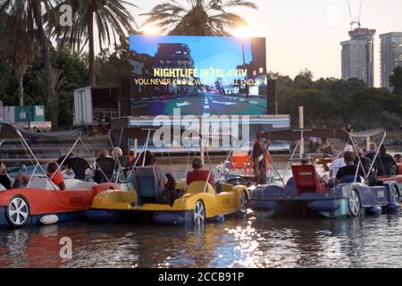 Tel Aviv, Israel. August 2020. Am 20. August 2020 sitzen Menschen in Booten, wie sie in einem schwimmenden Kino in Tel Aviv, Israel, sitzen. Das schwimmende Segelkino ist eine Initiative der Stadtverwaltung von Tel Aviv, um Menschen während der Beschränkungen der COVID-19-Pandemie kulturelle Veranstaltungen zu bieten. (Gideon Markowicz/JINI via Xinhua) Quelle: Xinhua/Alamy Live News Stockfoto