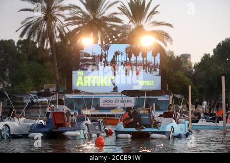 Tel Aviv, Israel. August 2020. Am 20. August 2020 sitzen Menschen in Booten, wie sie in einem schwimmenden Kino in Tel Aviv, Israel, sitzen. Das schwimmende Segelkino ist eine Initiative der Stadtverwaltung von Tel Aviv, um Menschen während der Beschränkungen der COVID-19-Pandemie kulturelle Veranstaltungen zu bieten. (Gideon Markowicz/JINI via Xinhua) Quelle: Xinhua/Alamy Live News Stockfoto