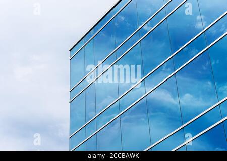 Außenansicht der typischen blauen Glasfassade eines modernen Bürogebäudes. Spiegelung des Himmels. Stockfoto
