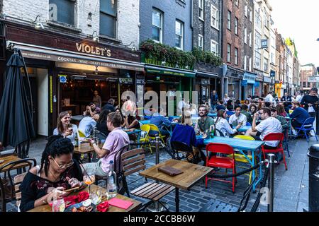 Kunden, die im Freien in einer Fußgängerzone, Berwick Street, Soho, London, Großbritannien, speisen. Stockfoto