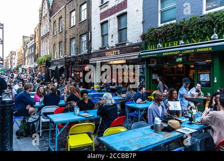 Kunden, die im Freien in einer Fußgängerzone, Berwick Street, Soho, London, Großbritannien, speisen. Stockfoto