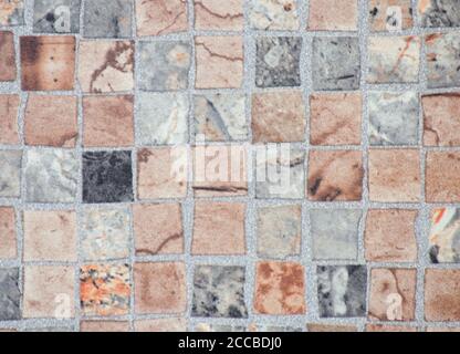 Ein Fragment einer Mauer aus quadratischen Steinen mit einem Mosaikmuster. Hintergrund, Textur, Nahaufnahme. Stockfoto