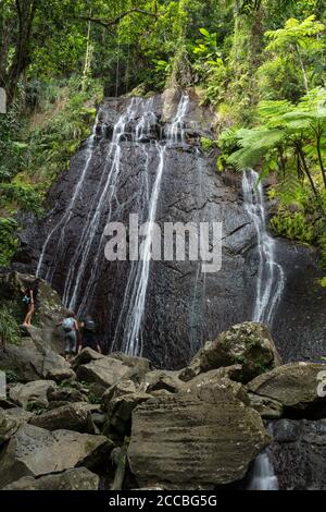 Touristen bei La Coca Falls im tropischen El Yunque National Forest in Puerto Rico. Stockfoto