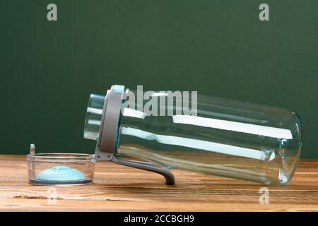 Transparente Plastikwasserflasche für Jungen mit geöffnetem Deckel Auf einem Holztisch Stockfoto